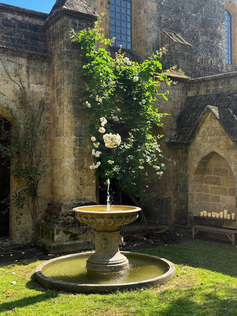 Sonniger Klostergarten mit Rosen und Brunnen